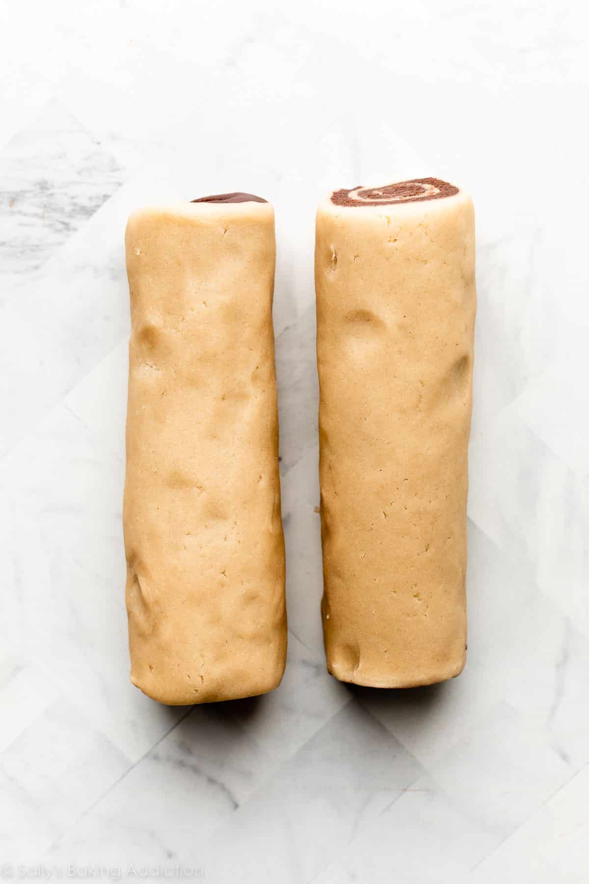 two dough logs on marble counter.