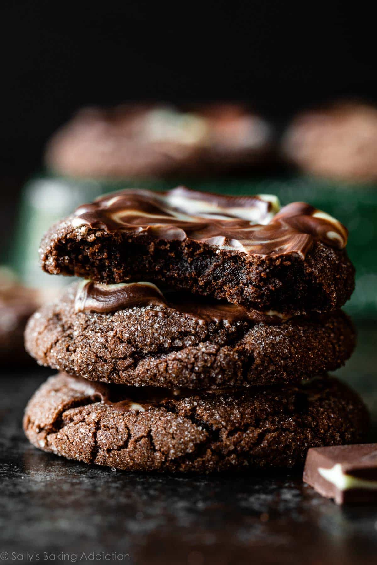 stack of andes mint frosted chocolate cookies with top cookie broken in half.