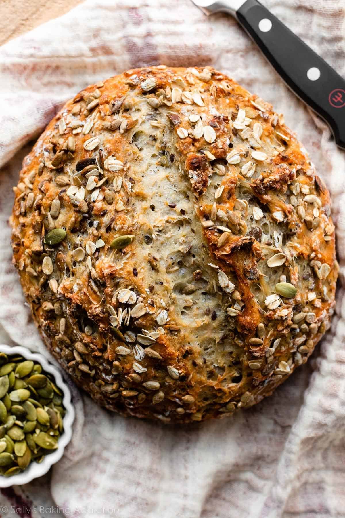round boule of seeded bread on ivory linen.