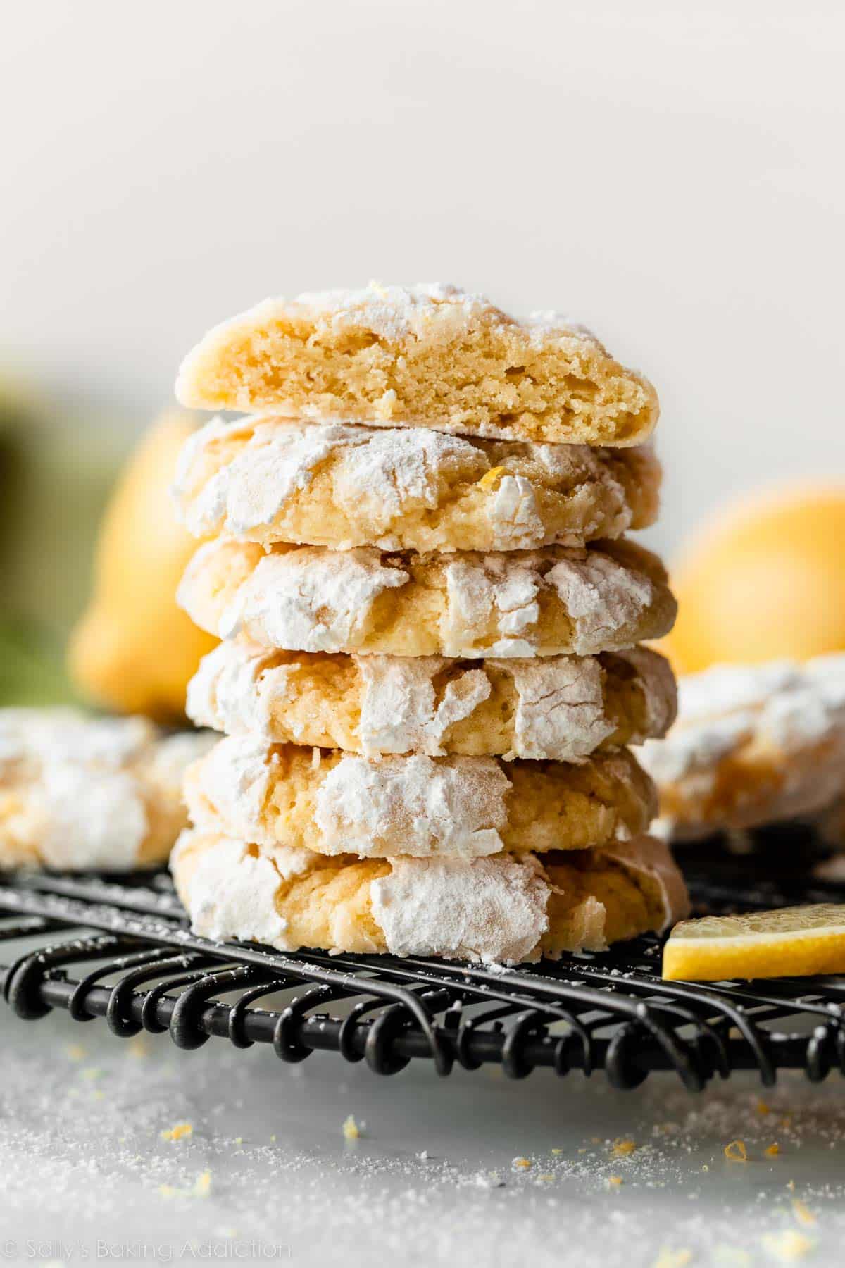 stack of lemon crinkle cookies coated in confectioners' sugar.