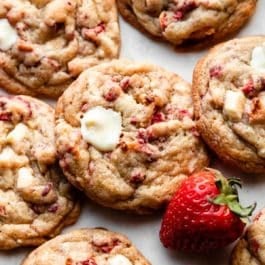 white chocolate strawberries & cream cookies on marble backdrop with fresh strawberry.
