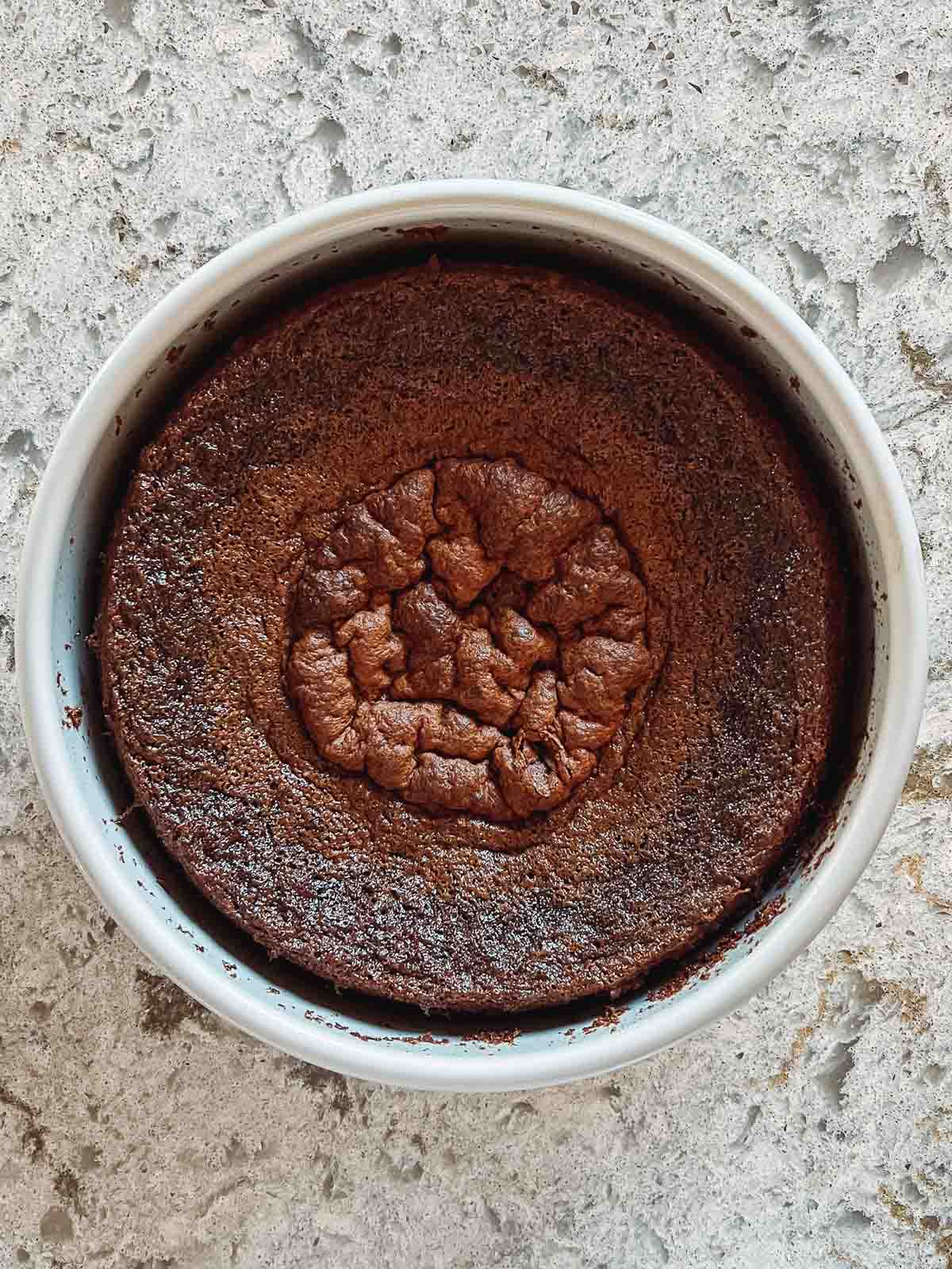 shrunken and shriveled chocolate cake in cake pan.