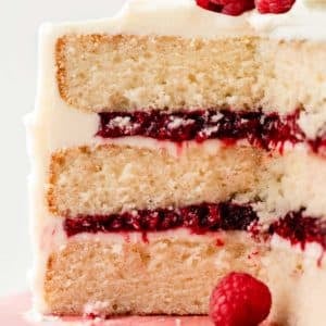 3 layer white vanilla cake cut open to reveal raspberry cake filling inside.