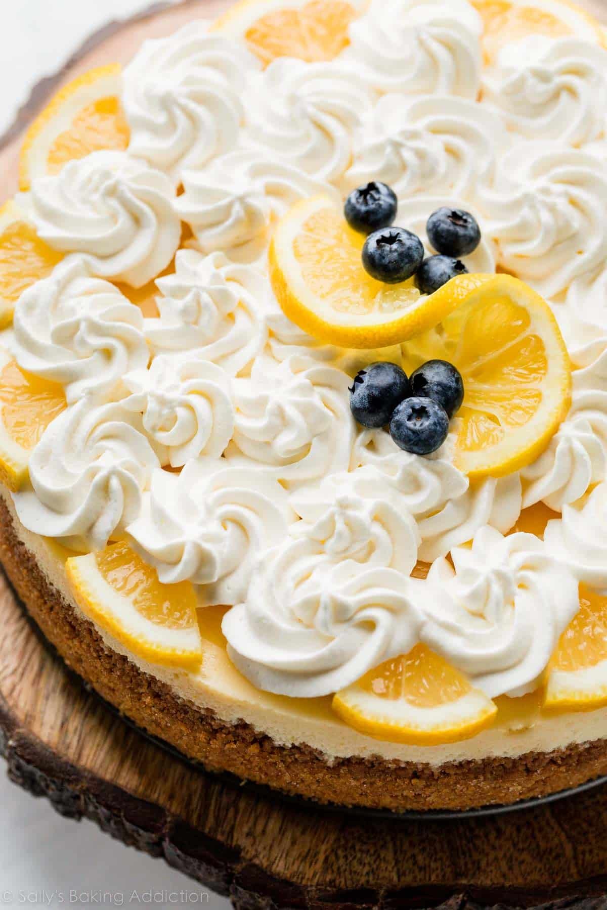 lemon cheesecake with whipped cream and blueberries on top.