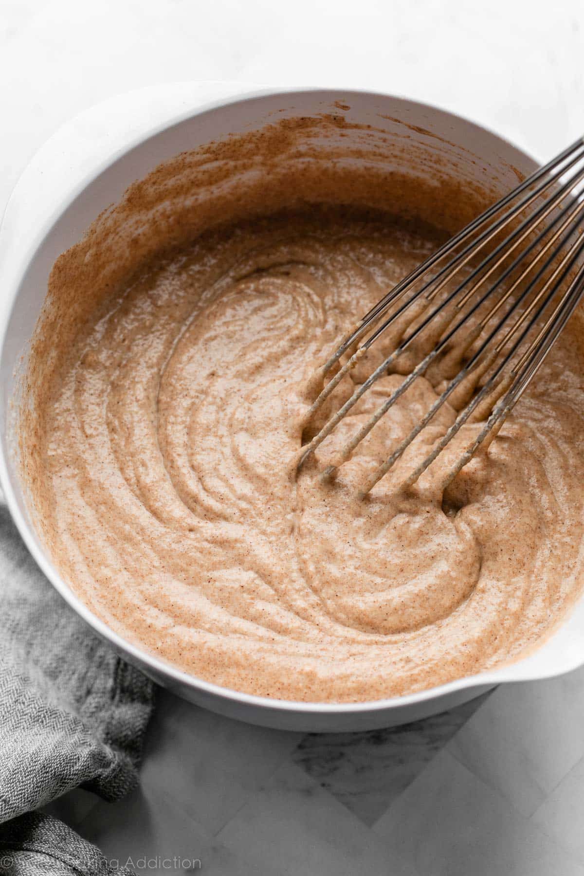 whole wheat batter in white mixing bowl with whisk.