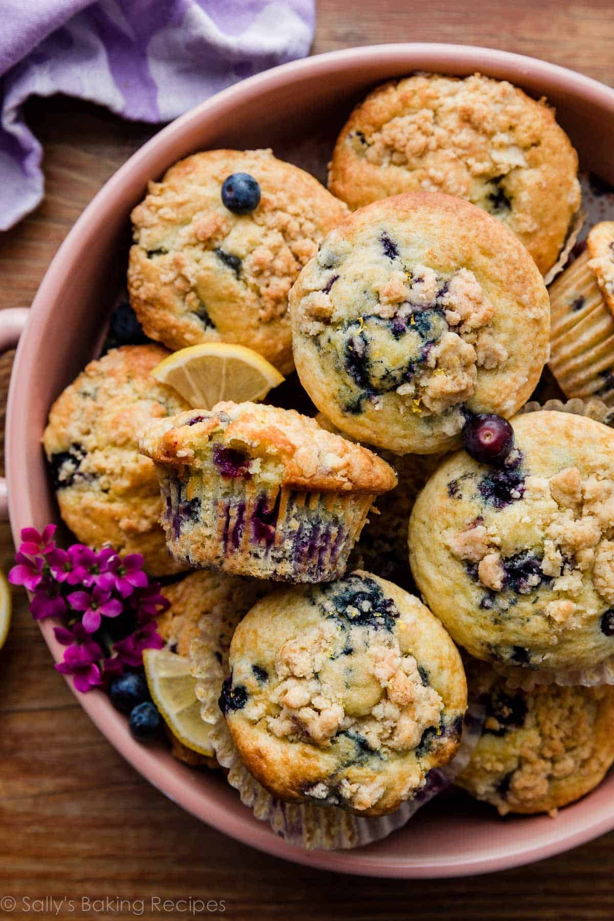 lemon blueberry muffins with crumb topping in pink bowl.