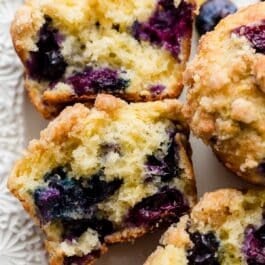 lemon blueberry muffins cut in half to reveal the blueberries in the center.
