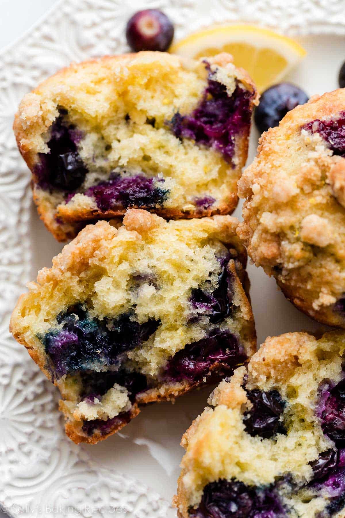 lemon blueberry muffin cut in half to show blueberries in center.