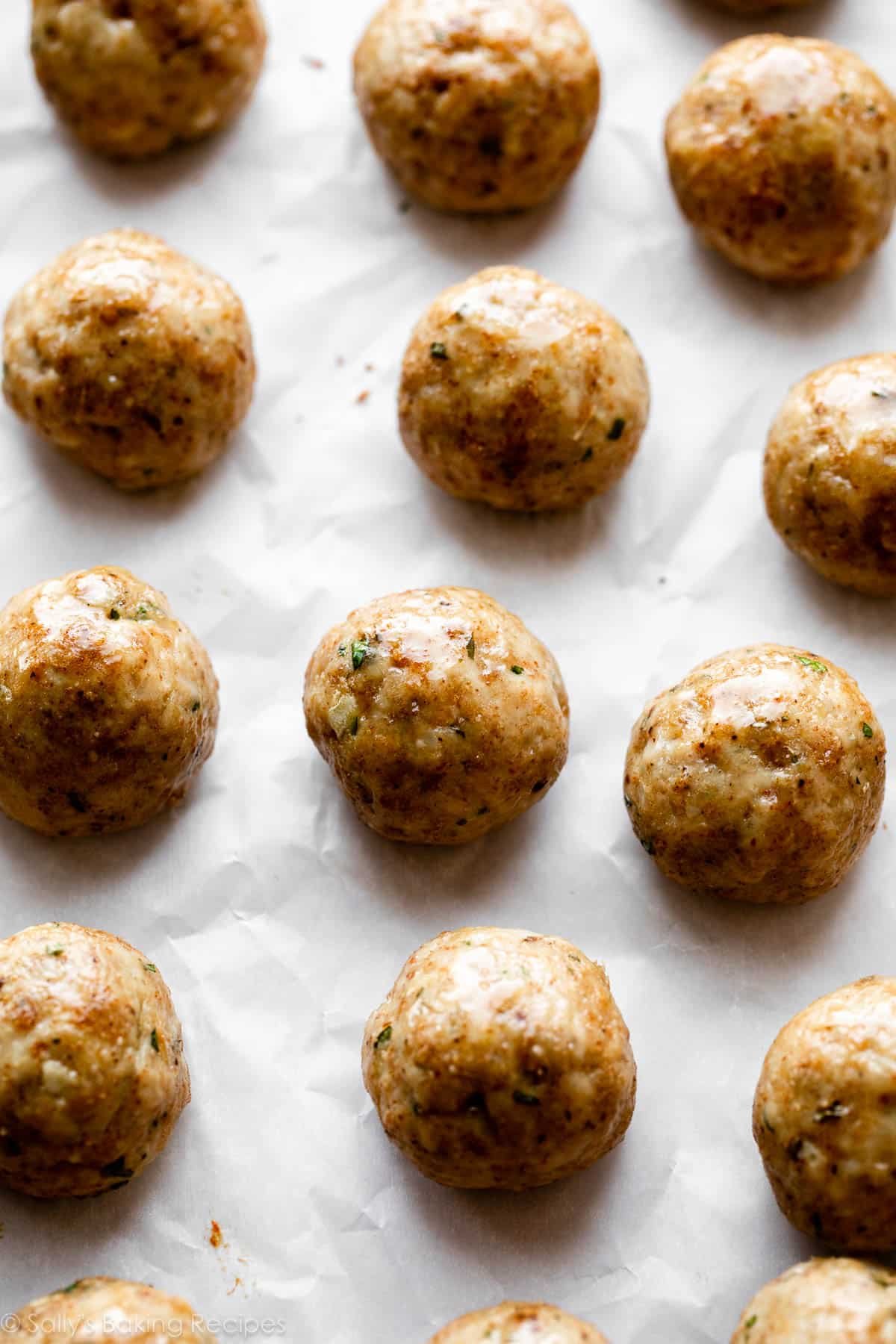 baked chicken meatballs on parchment paper.