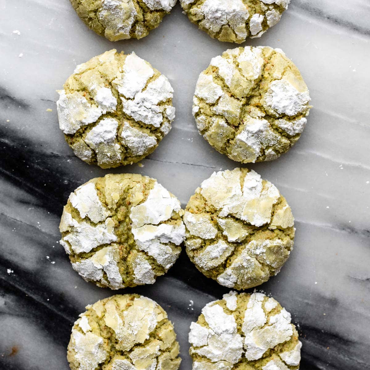 green crinkle cookies with confectioners' sugar on top.