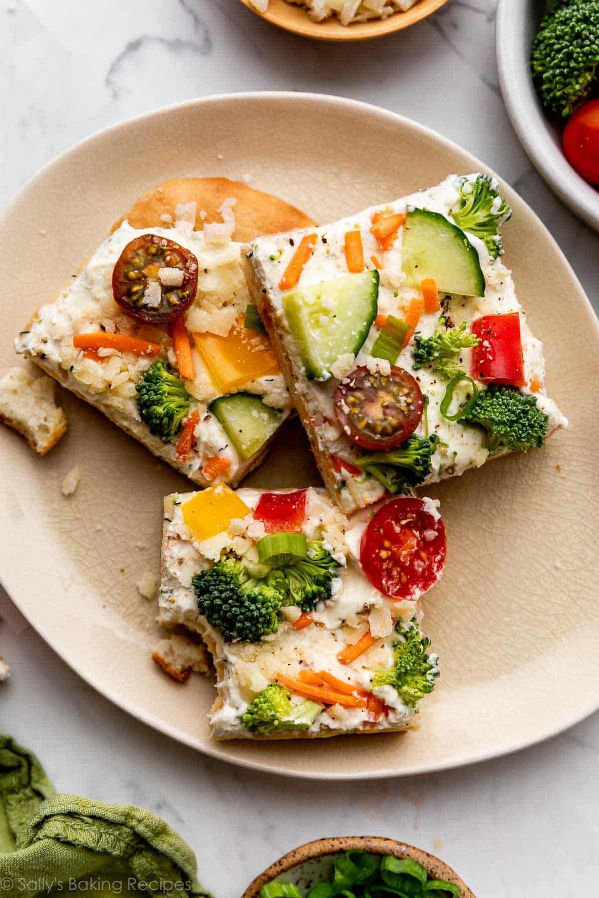 plate with 3 slices of veggie pizza on top, and one has a bite taken out.