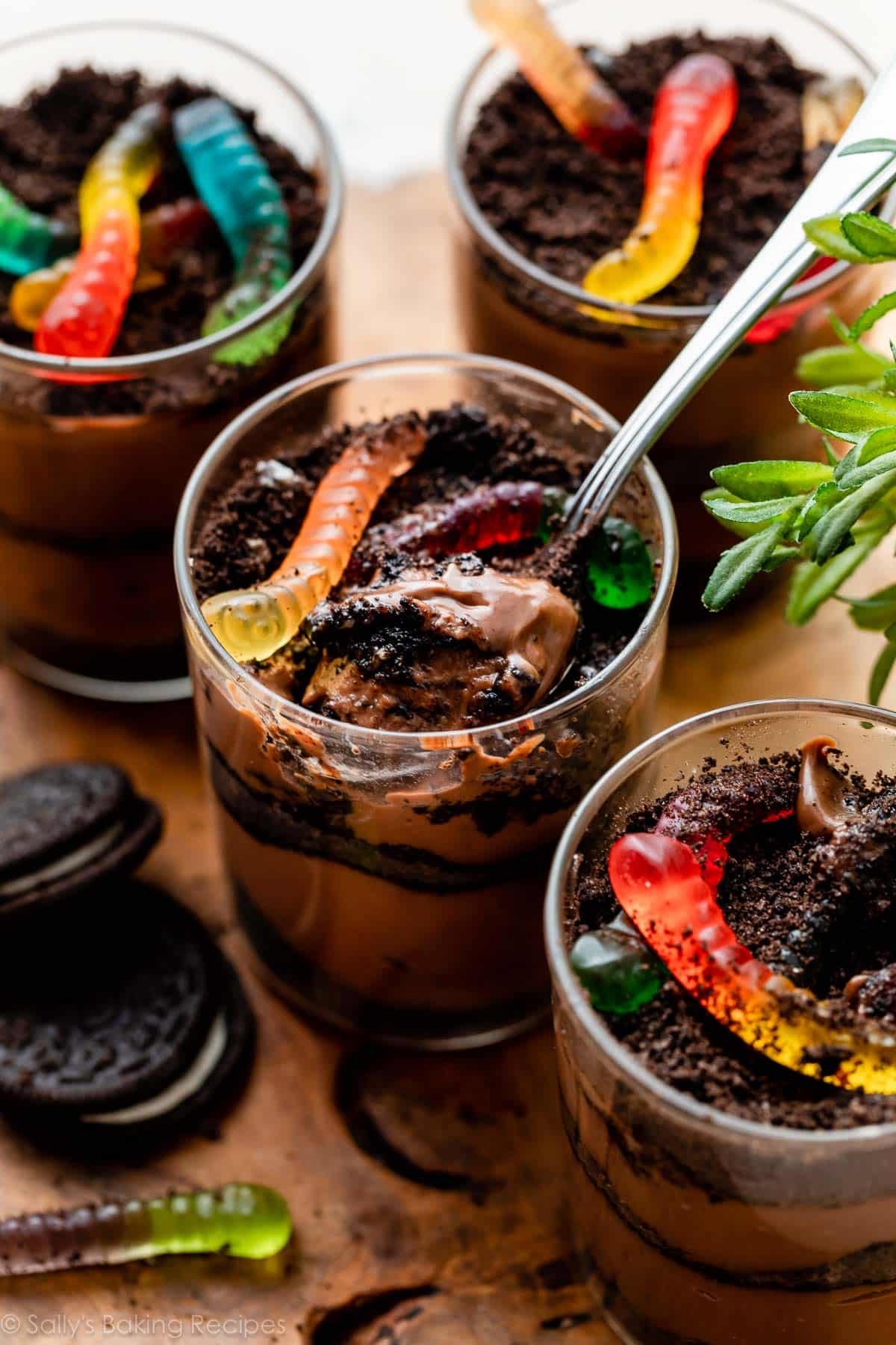 dirt pudding cups with crushed Oreo cookies and gummy worms on top.