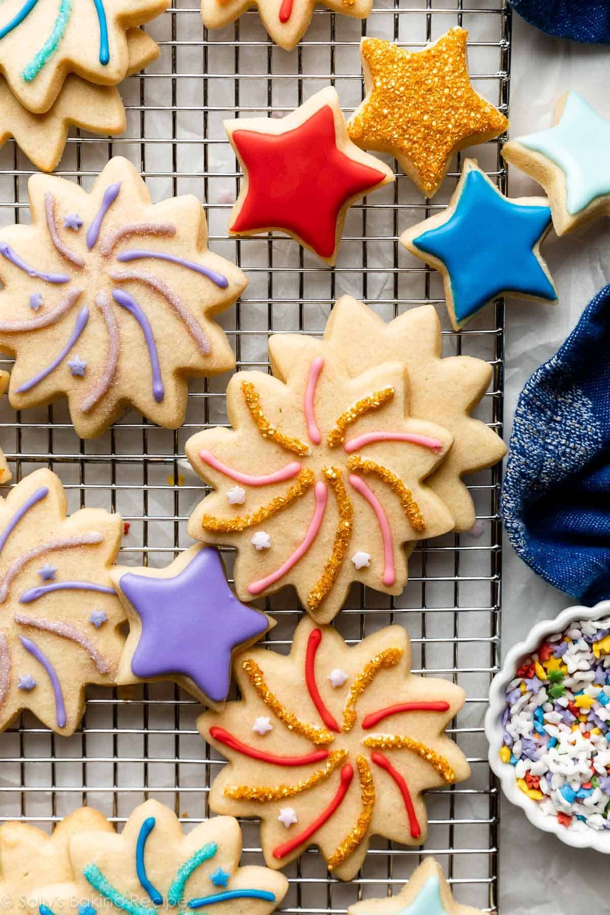 decorated fireworks celebration and star-shaped sugar cookies with various colors of icing and gold sprinkles.