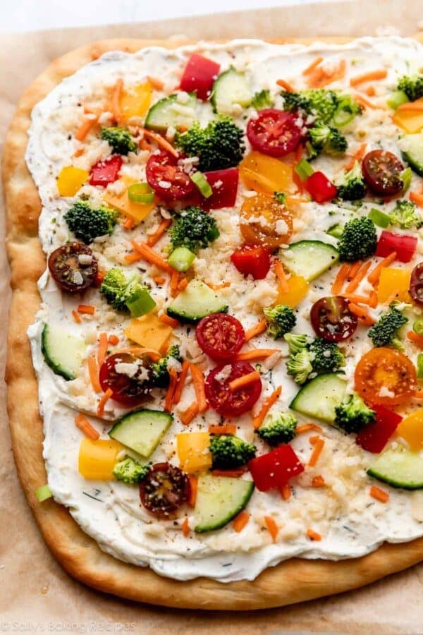 vegetable pizza on flatbread crust with cream cheese topping.