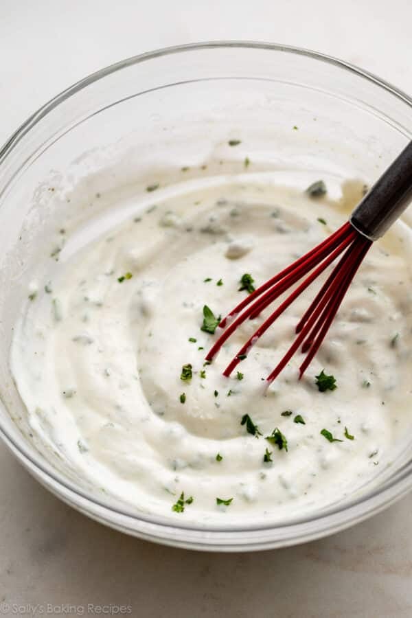 Greek yogurt herb mixture in glass bowl.