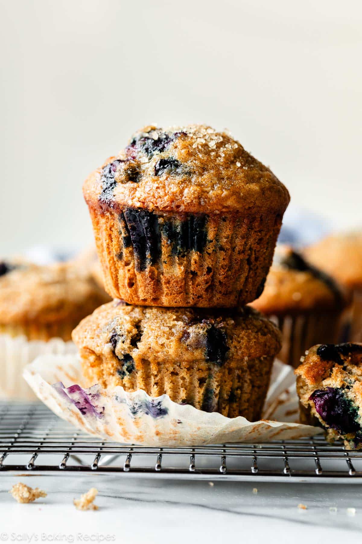 stack of two healthy blueberry banana muffins on cooling rack.
