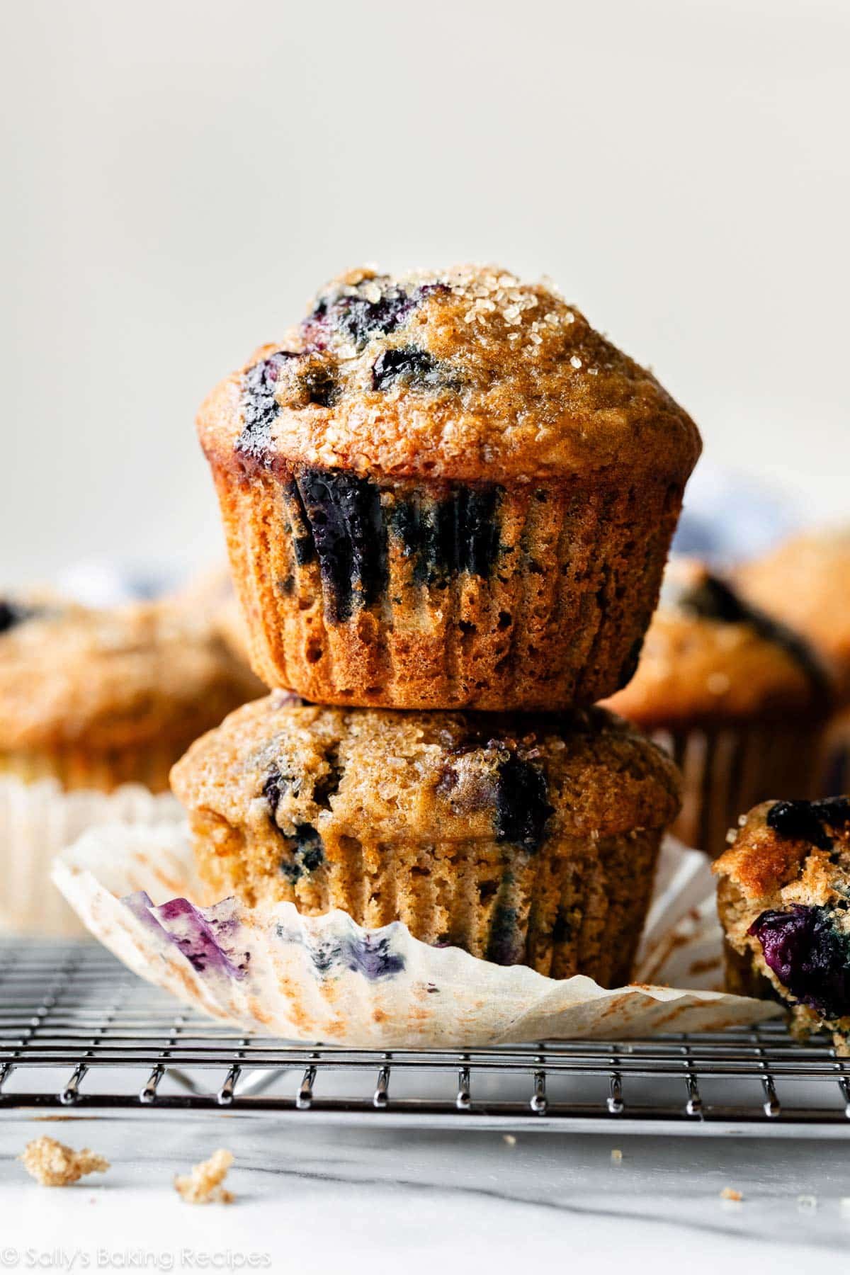 stack of two healthy blueberry banana muffins on cooling rack.