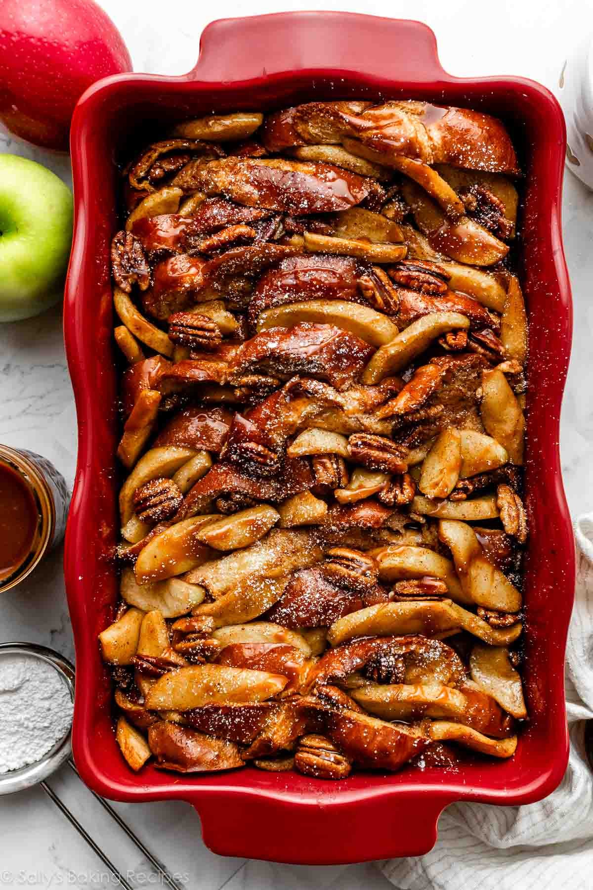 baked apple cider french toast in red casserole dish.