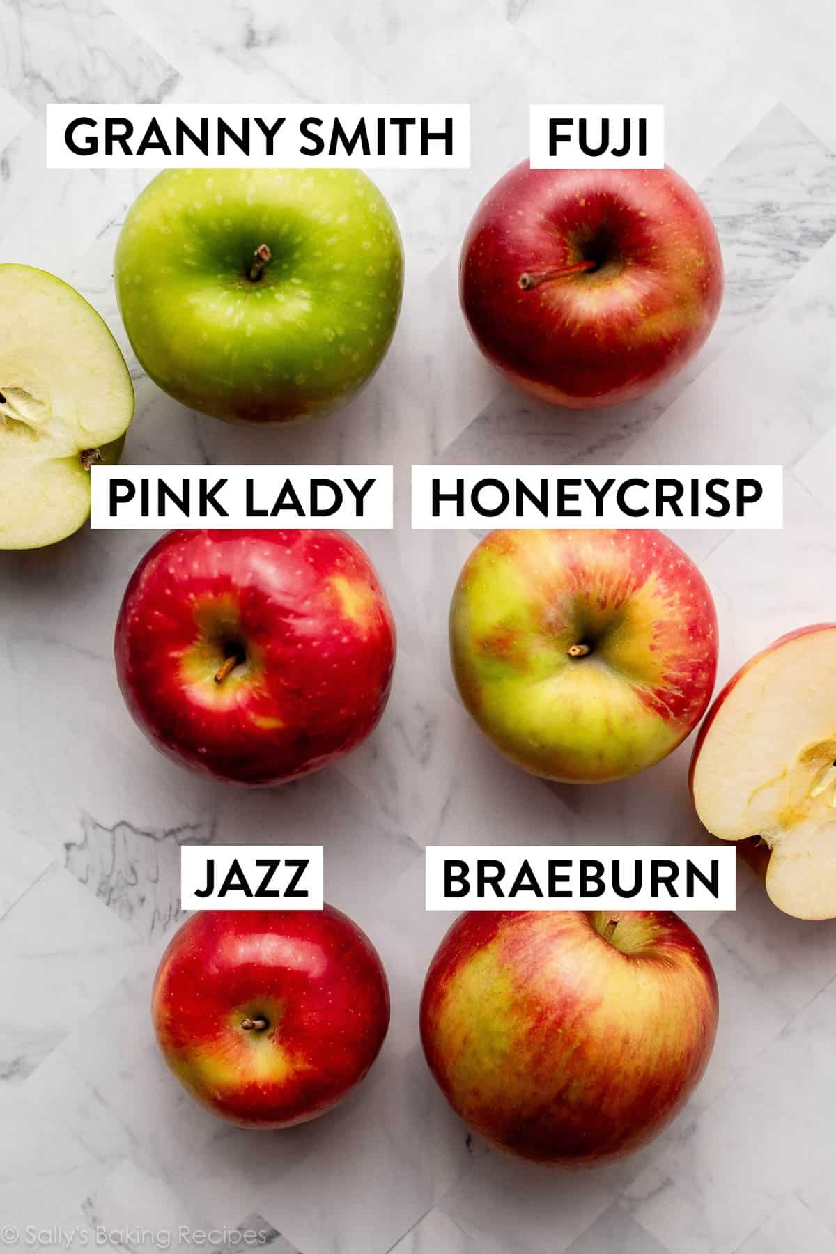various apple varieties on marble countertop.
