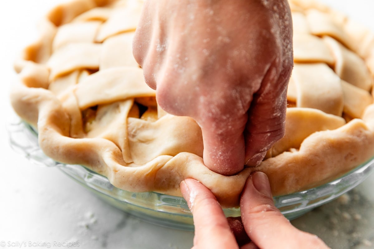 hands fluting pie crust edges.