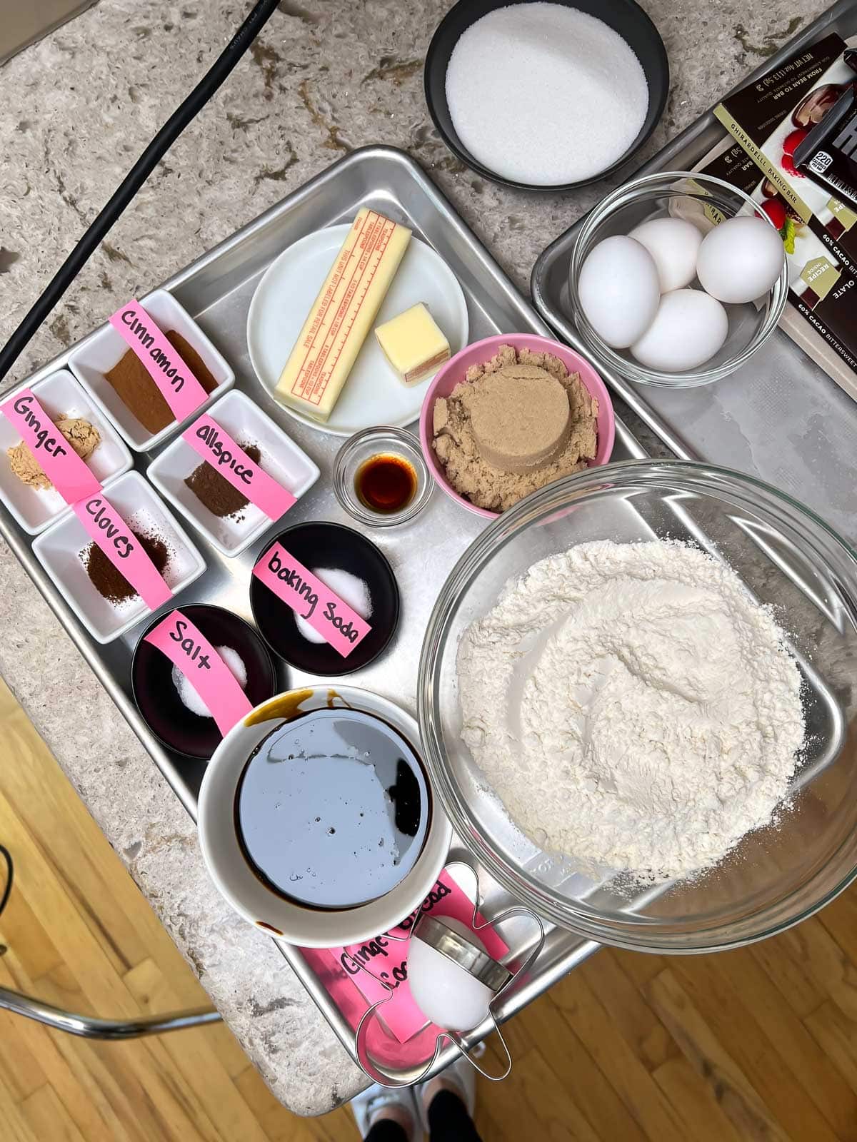 ingredients measured out in separate bowls with pink labels on baking sheet.