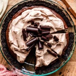 sliced chocolate pudding pie in Oreo cookie crust with mocha whipped cream on top.