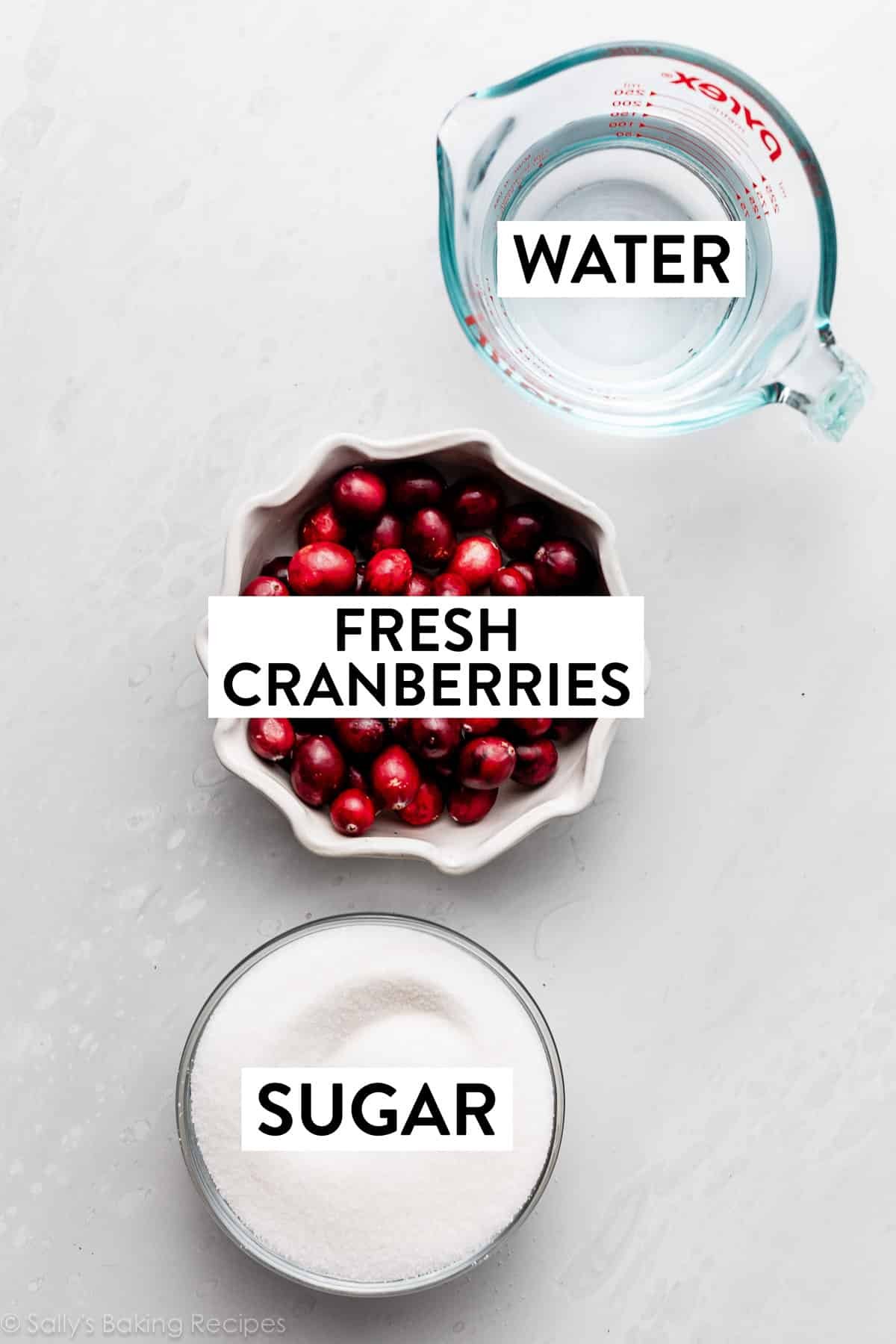 fresh cranberries, water, and sugar in bowls on counter.