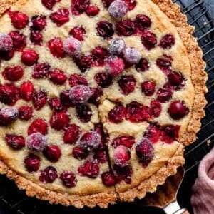 cranberry frangipane tart with sugared cranberries on top.