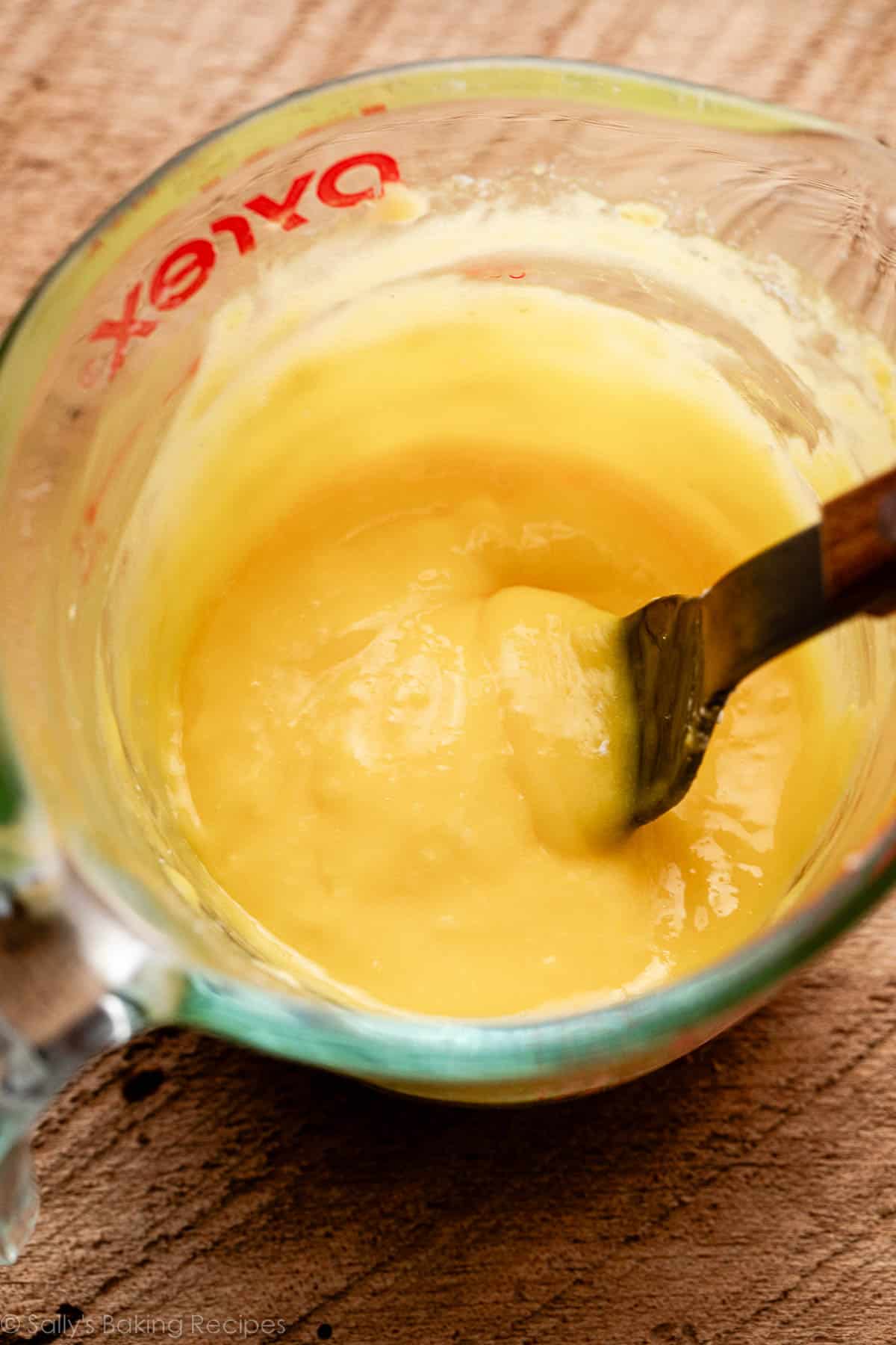 thick egg yolk mixture in glass measuring cup.