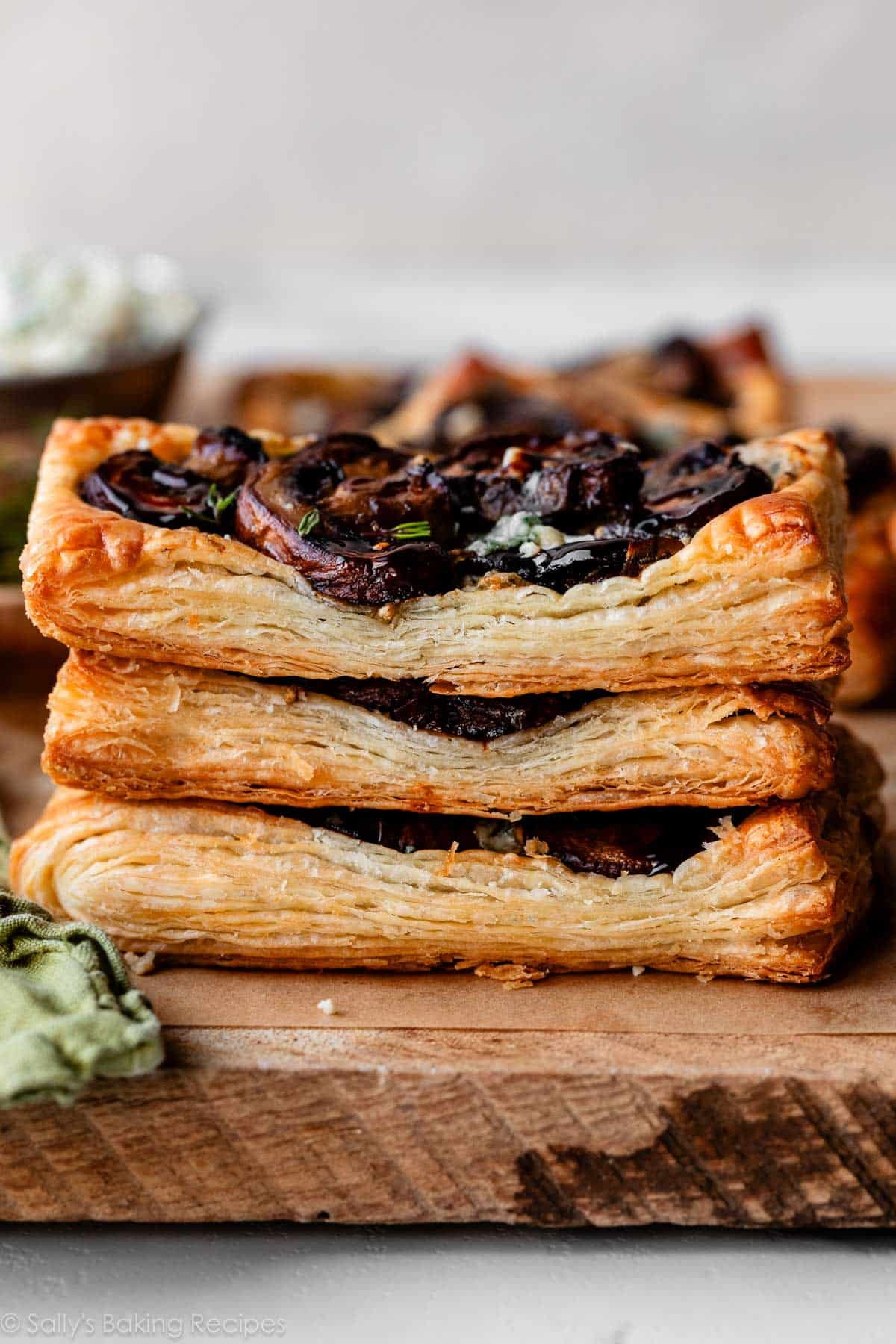 stack of 3 puff pastry tarts with mushrooms on top.