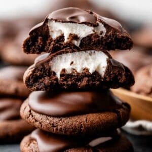stack of hot cocoa cookies with top two broken open to reveal marshmallow inside.