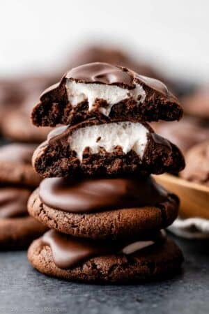 stack of hot cocoa cookies with top two broken open to reveal marshmallow inside.