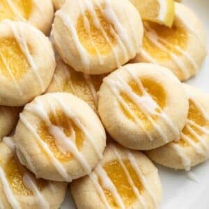 close-up photo of lemon thumbprints with icing on white plate.