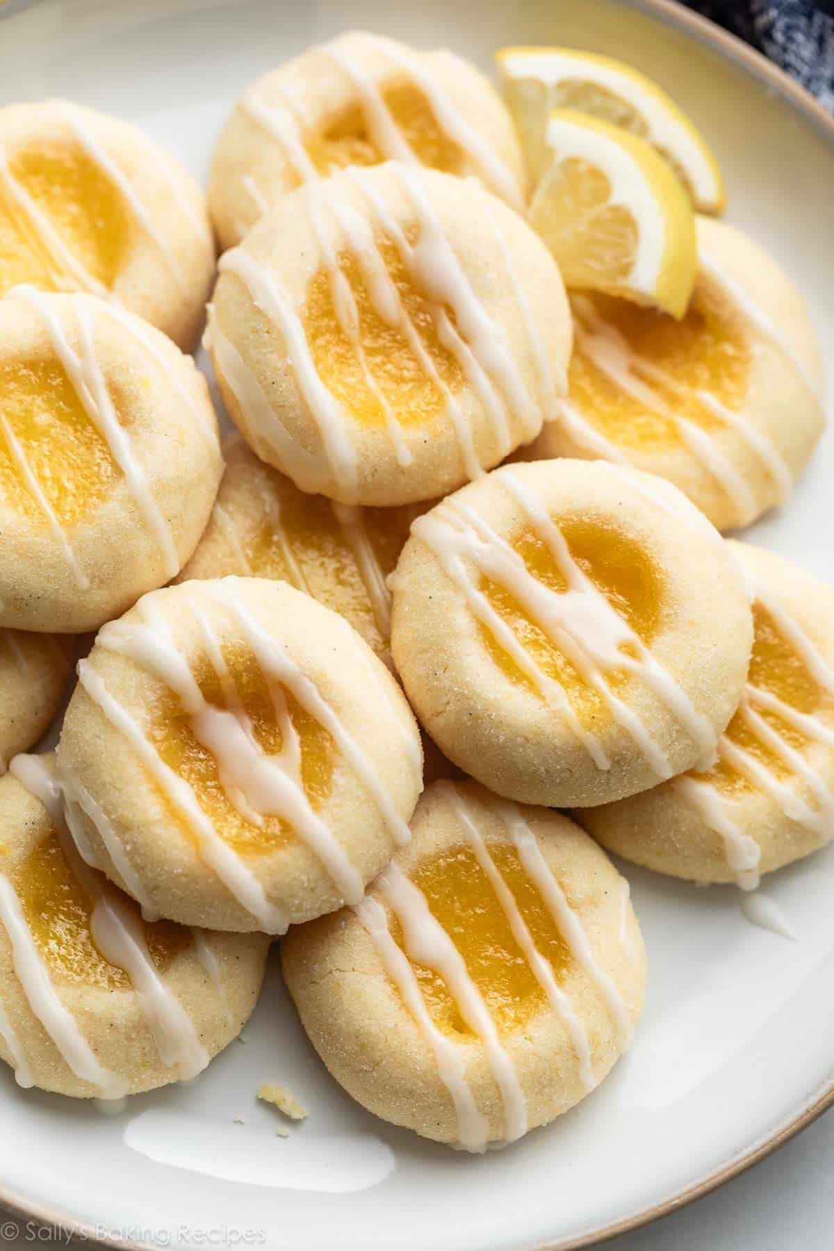 close-up photo of lemon thumbprints with icing on white plate.