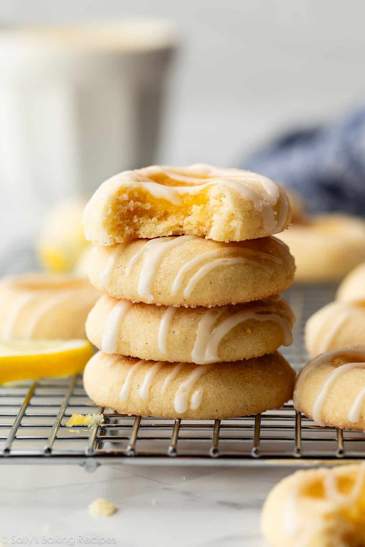 stack of lemon curd thumbprint cookies on cooling rack.