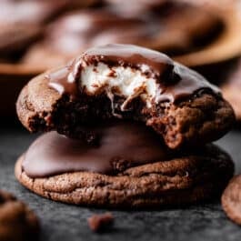 stack of two marshmallow-filled hot cocoa cookies with melted chocolate on top.