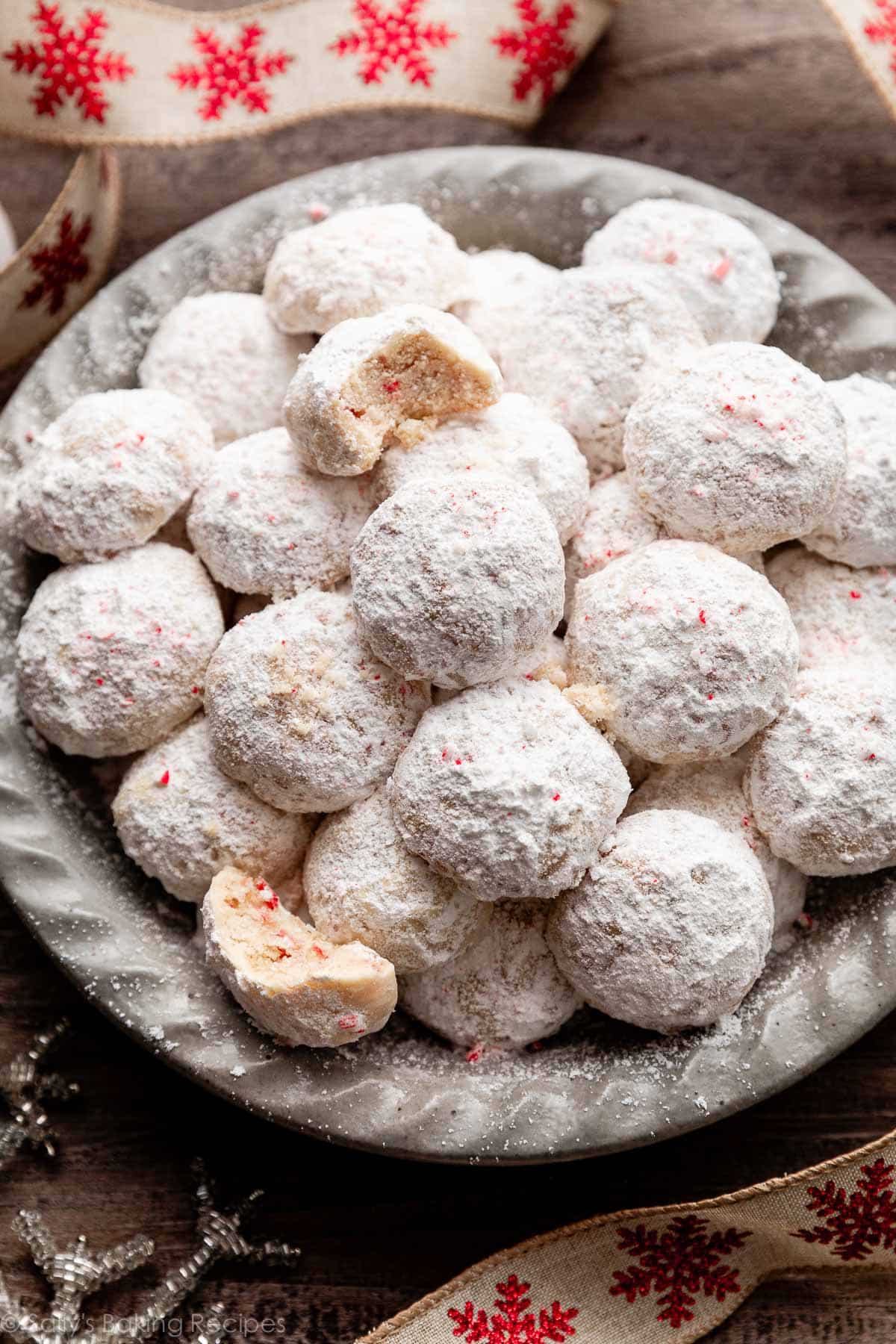 peppermint candy cane snowball cookies in gray dish.