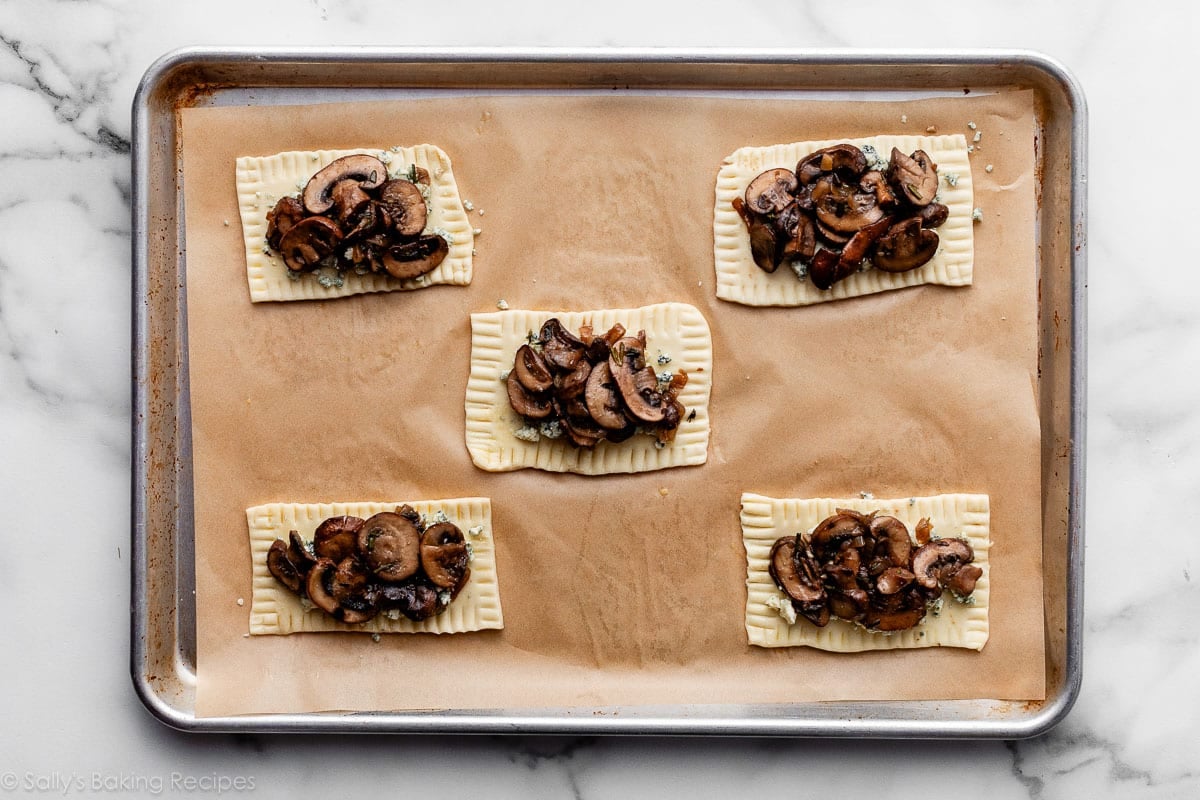 mushrooms on top of dough rectangles that have crimped edges.