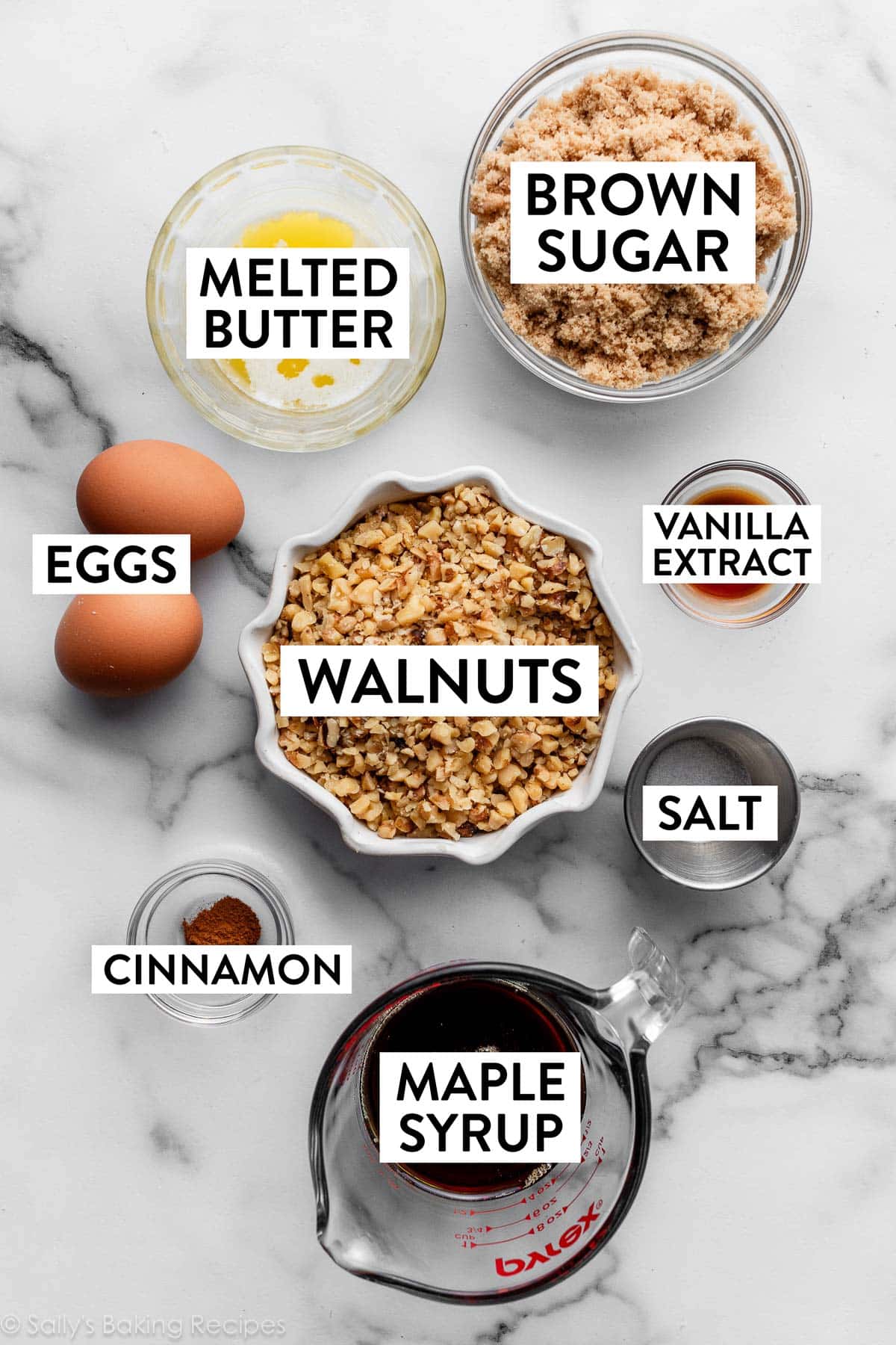 ingredients on counter including walnuts, melted butter, brown sugar, maple syrup, and eggs.