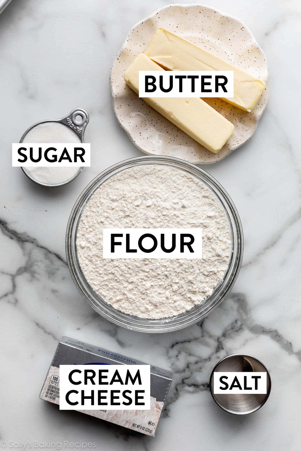 ingredients measured on marble counter including cream cheese, butter, sugar, flour, and salt.
