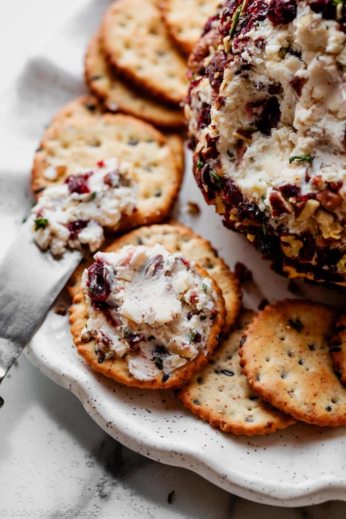 cranberry cheese spread on cracker on plate.