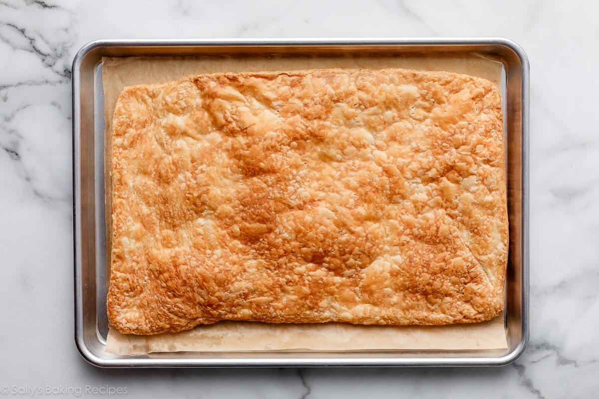 baked homemade puff pastry on lined baking sheet.