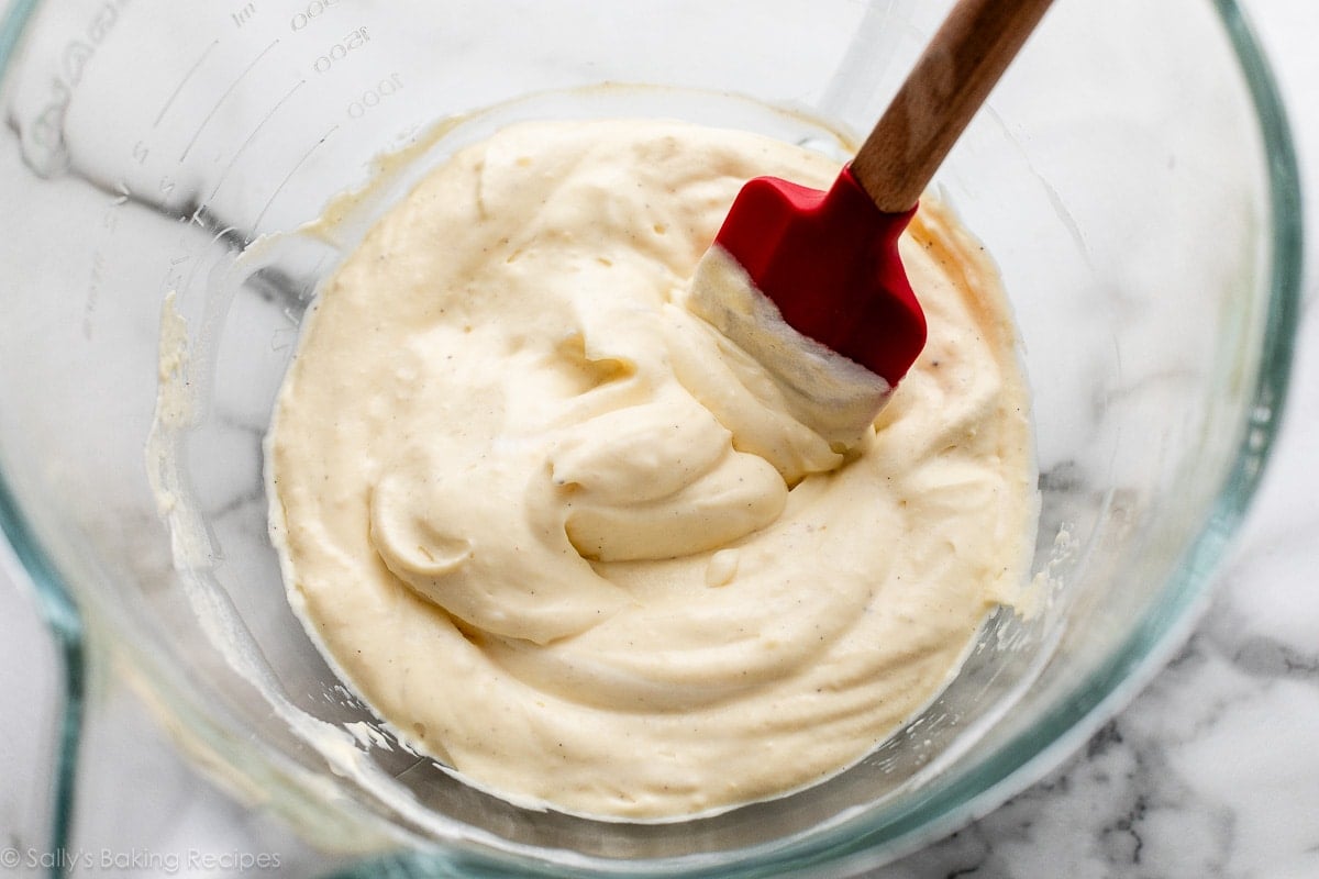 vanilla bean pastry cream with whipped cream folded in with red spatula.