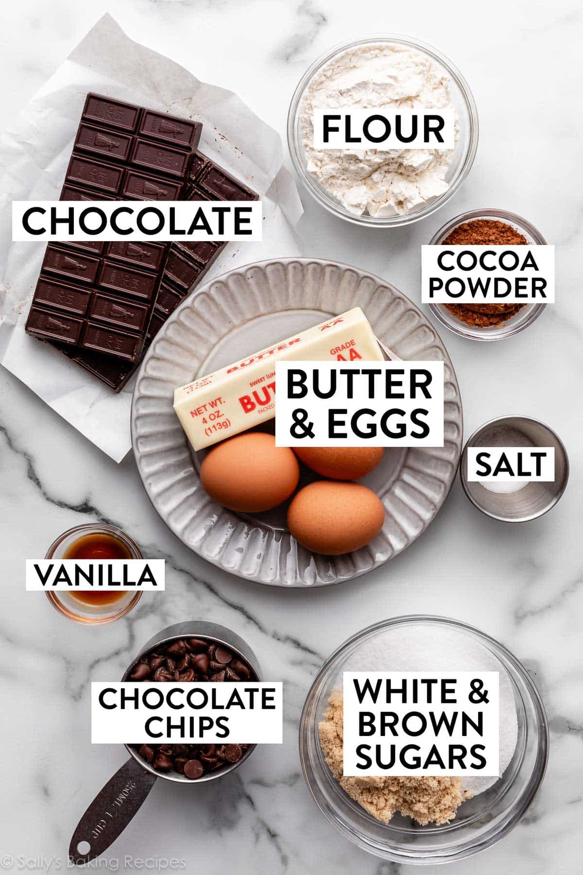 ingredients on counter including butter, eggs, chocolate, flour, and cocoa powder.