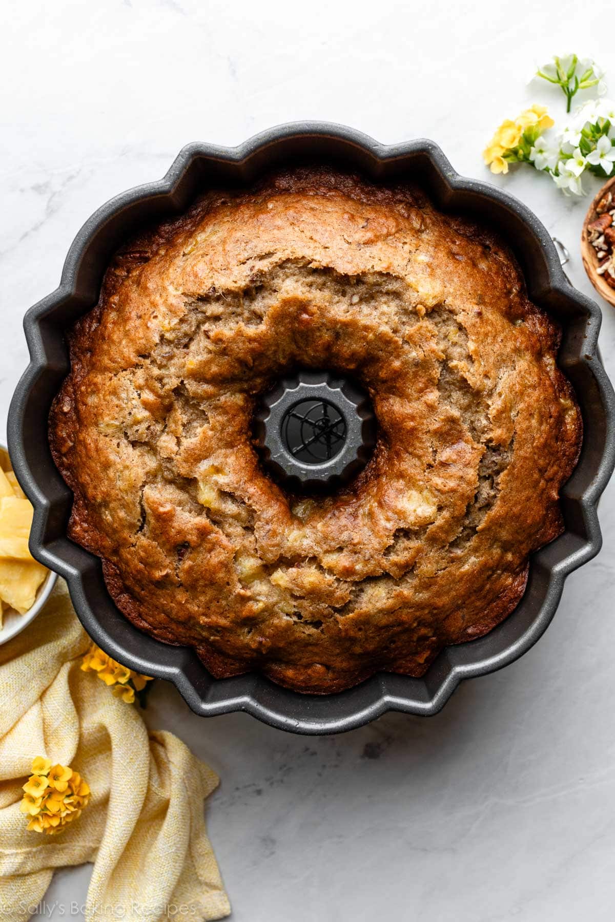 pineapple and banana Bundt cake in pan with yellow linen.