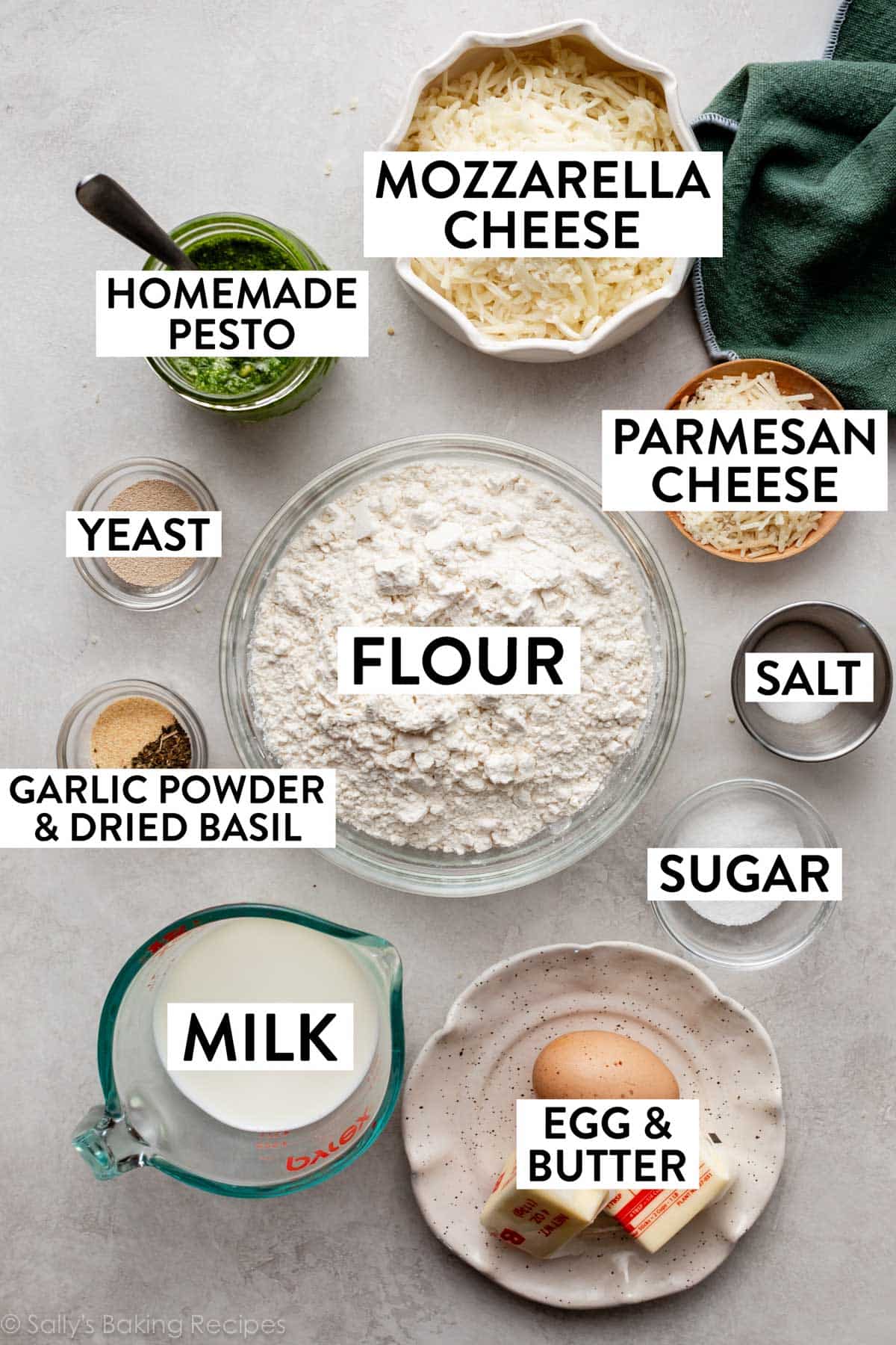 ingredients in bowls including flour, mozzarella cheese, salt, egg, butter, milk, yeast, and garlic powder.
