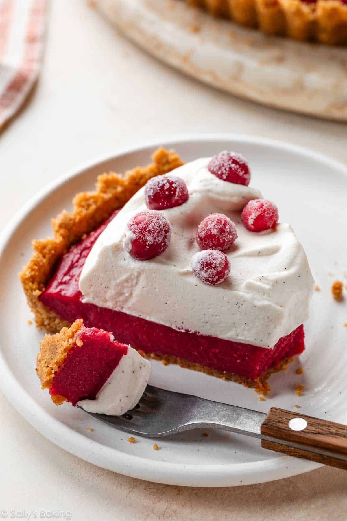 cranberry curd tart with whipped cream on plate.