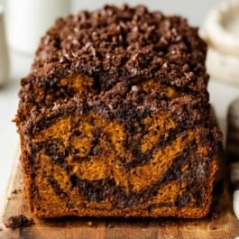 sliced chocolate marble pumpkin bread on a cutting board.