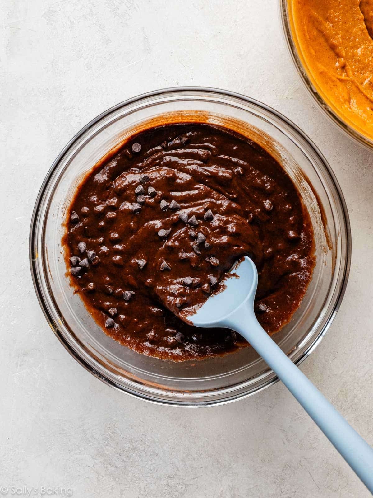 spoon stirring mini chocolate chips into batter.