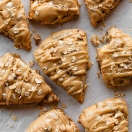 maple oat pecan scones topped with oats and drizzled with icing.